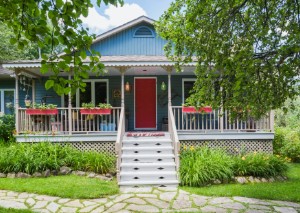 A nice house with blue walls and a red door.